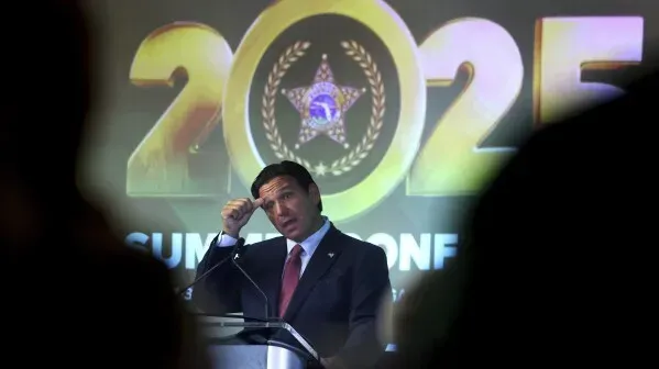 حاكم فلوريدا رون ديسانتيس يتحدث في مؤتمر صحفي حول زيادة عمليات الإعدام في الولاية، مع خلفية تحمل شعار عام 2025.