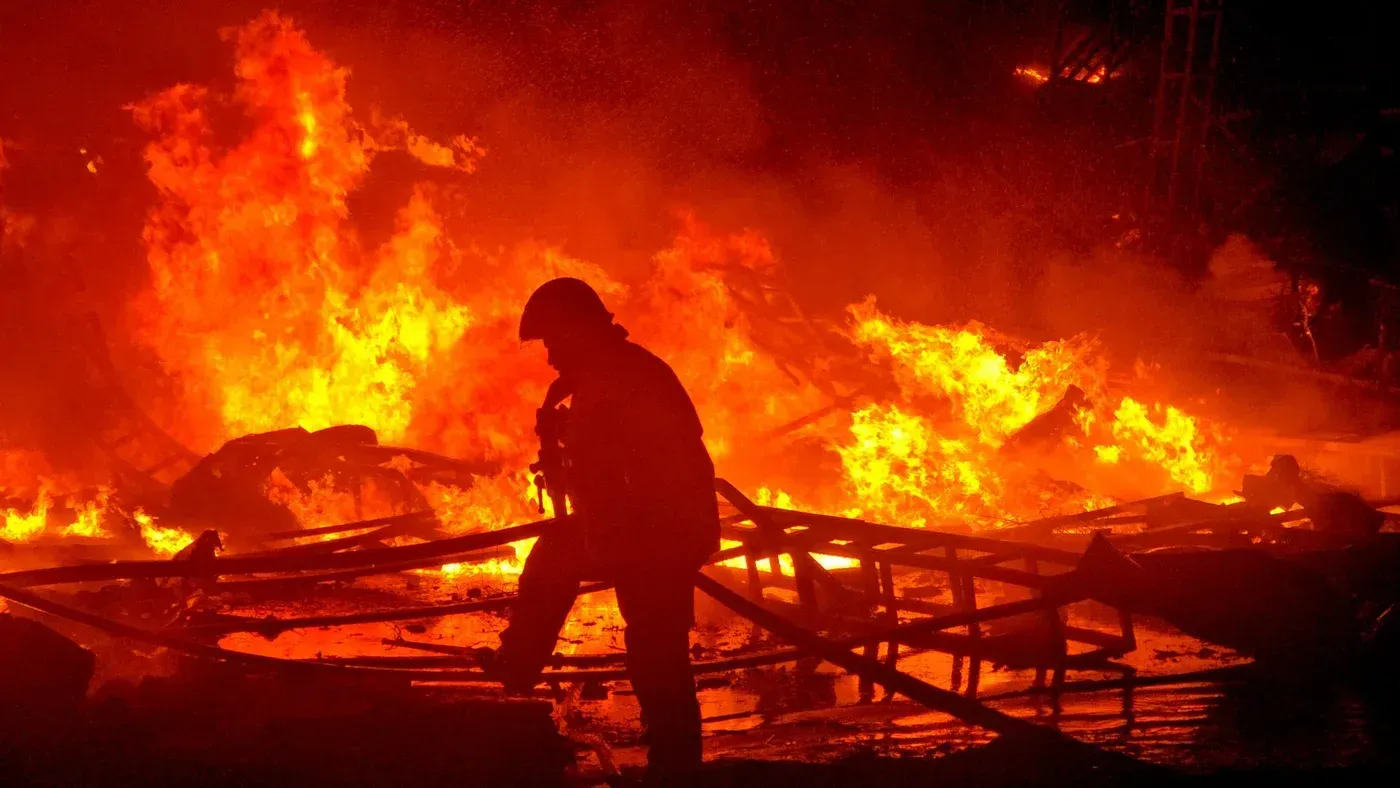 شخصية عسكرية واقفة أمام حريق هائل، تعكس تصاعد التوترات في لبنان نتيجة الصراع مع إسرائيل وتأثيره على المدنيين.