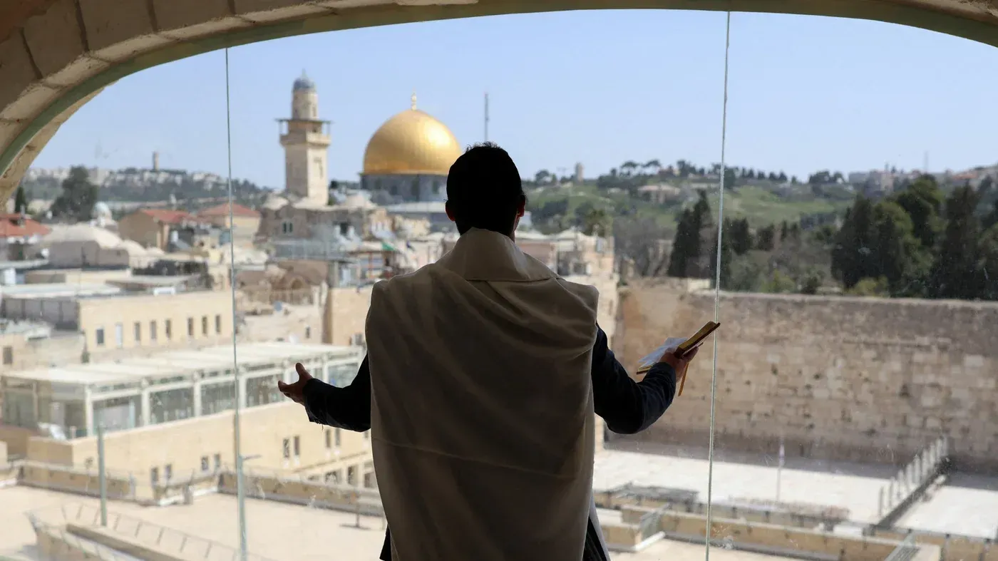 مصلٍ يهودي يقف أمام حائط البراق في القدس، مستعرضًا المسجد الأقصى، في ظل قيود على وصول الفلسطينيين للموقع.