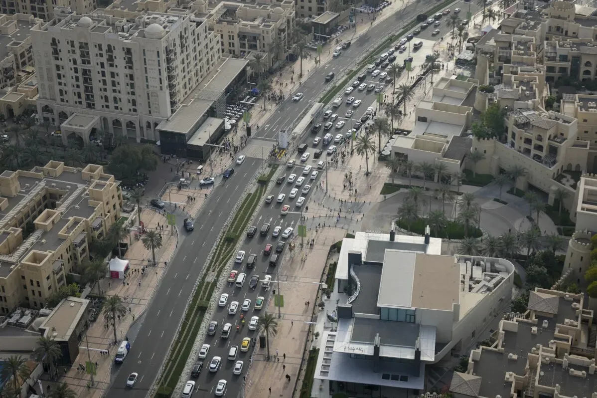 ازدحام مروري كثيف في دبي، يُظهر السيارات في طريق الشيخ زايد والمباني السكنية المحيطة، مع تأثير النمو السكاني على الحركة.