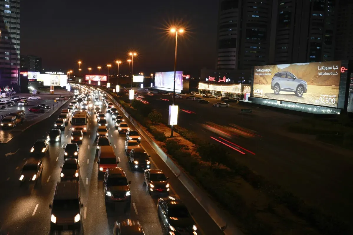 ازدحام مروري في دبي ليلاً، مع أضواء المدينة الساطعة على الجانبين، يمثل التحديات التي تواجهها المدينة بسبب تزايد عدد السكان والمركبات.