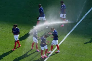 لاعبو منتخب فرنسا يستخدمون رشاشات المياه لتبريد أجسامهم خلال مباراة في كأس العالم في ظل موجة حرّ شديدة تؤثر على أداء اللاعبين والمشجعين.