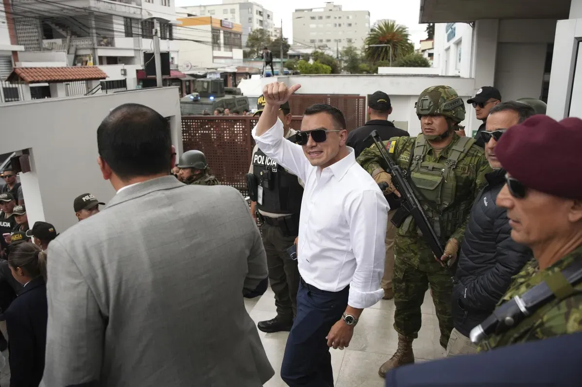 دانييل نوبوا، الرئيس الإكوادوري، يلوح بيده أثناء مغادرته مركز الاقتراع وسط حراسة مشددة من الشرطة والجيش.