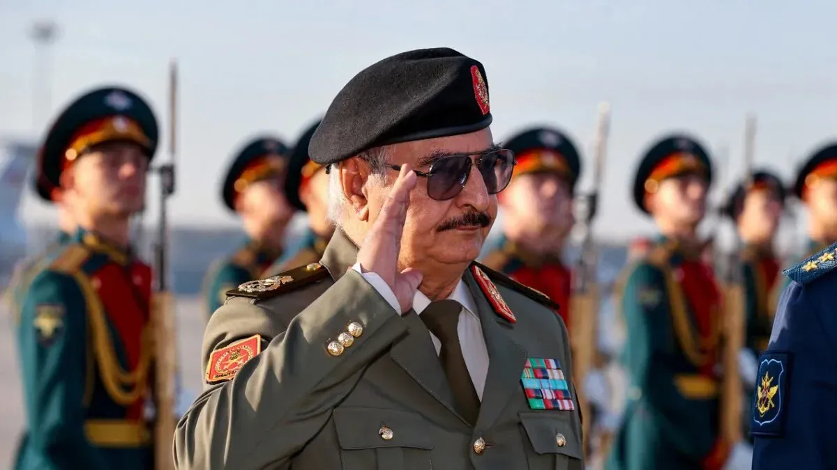 خليفة حفتر، القائد الفعلي لشرق ليبيا، يؤدي التحية العسكرية خلال مراسم رسمية، مع وجود حراس شرف خلفه.
