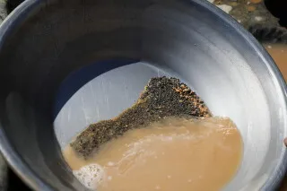 خليط من الرمال والماء في وعاء، يُظهر آثار التنقيب عن الذهب في المنطقة الحدودية بين مصر والسودان، حيث تم احتجاز المنقبين.