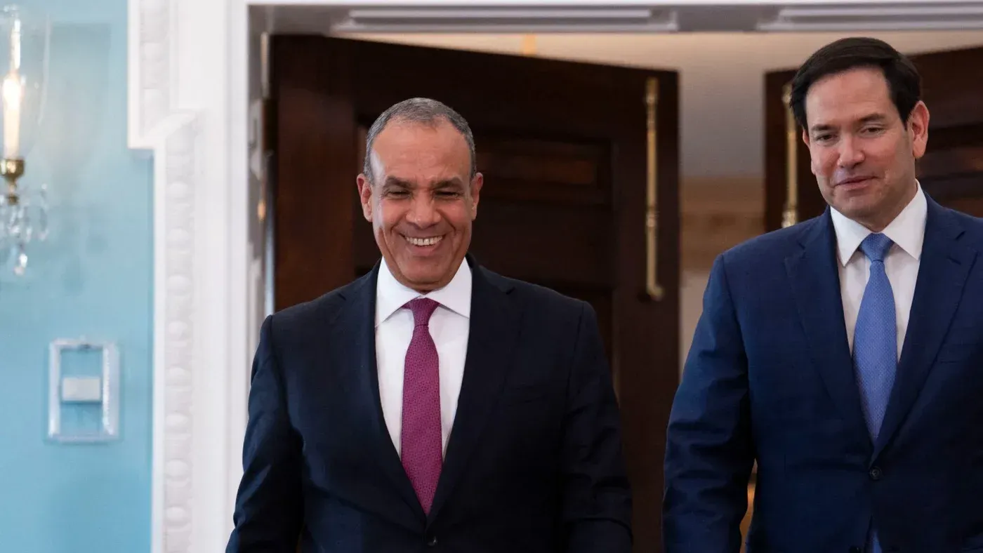 اجتماع بين مسؤول مصري وآخر أمريكي، حيث يظهران وهما يتحدثان بابتسامة، في سياق التوترات حول دعم مصر لحماس.