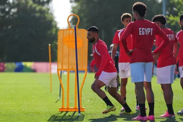 تدريب منتخب مصر لكرة القدم قبل مباراته المرتقبة ضد نيوزيلندا، حيث يظهر اللاعبون وهم يتدربون بجانب دمى تدريبية.