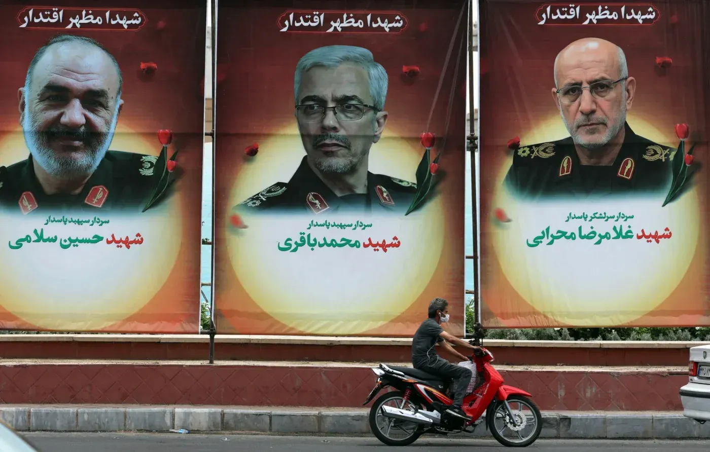 لافتات تذكارية لشهداء إيرانيين، تشمل صور حسين سلامي ومحمد باقري وغلام رضا محجري، مع ورود حمراء، في سياق التوترات الإسرائيلية الإيرانية.