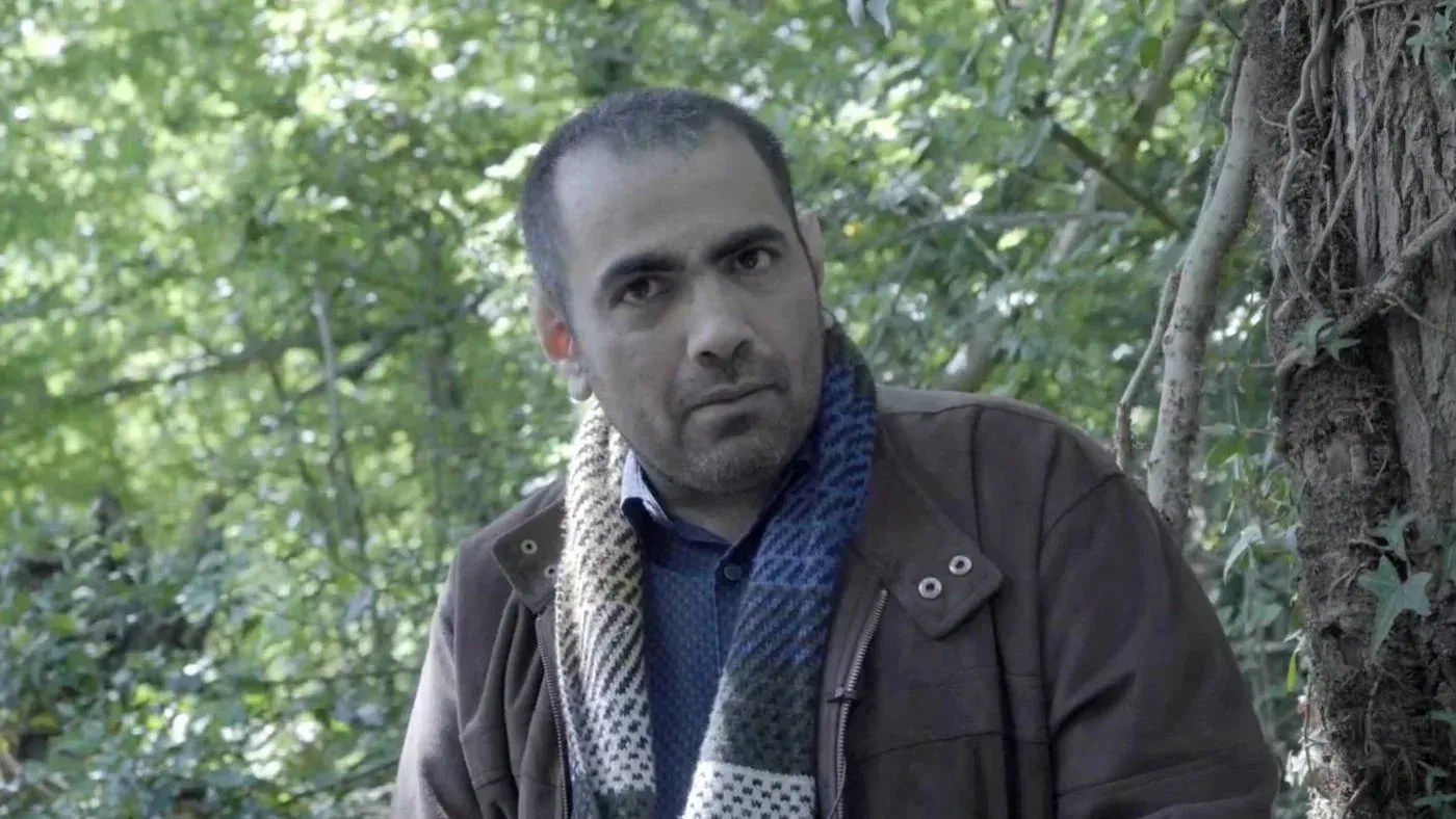 غانم المصارير، ناشط حقوقي سعودي، يظهر في غابة، مع تعبير جاد، بعد حكم المحكمة العليا بتعويضه عن الأذى النفسي الناتج عن اختراق هاتفه.