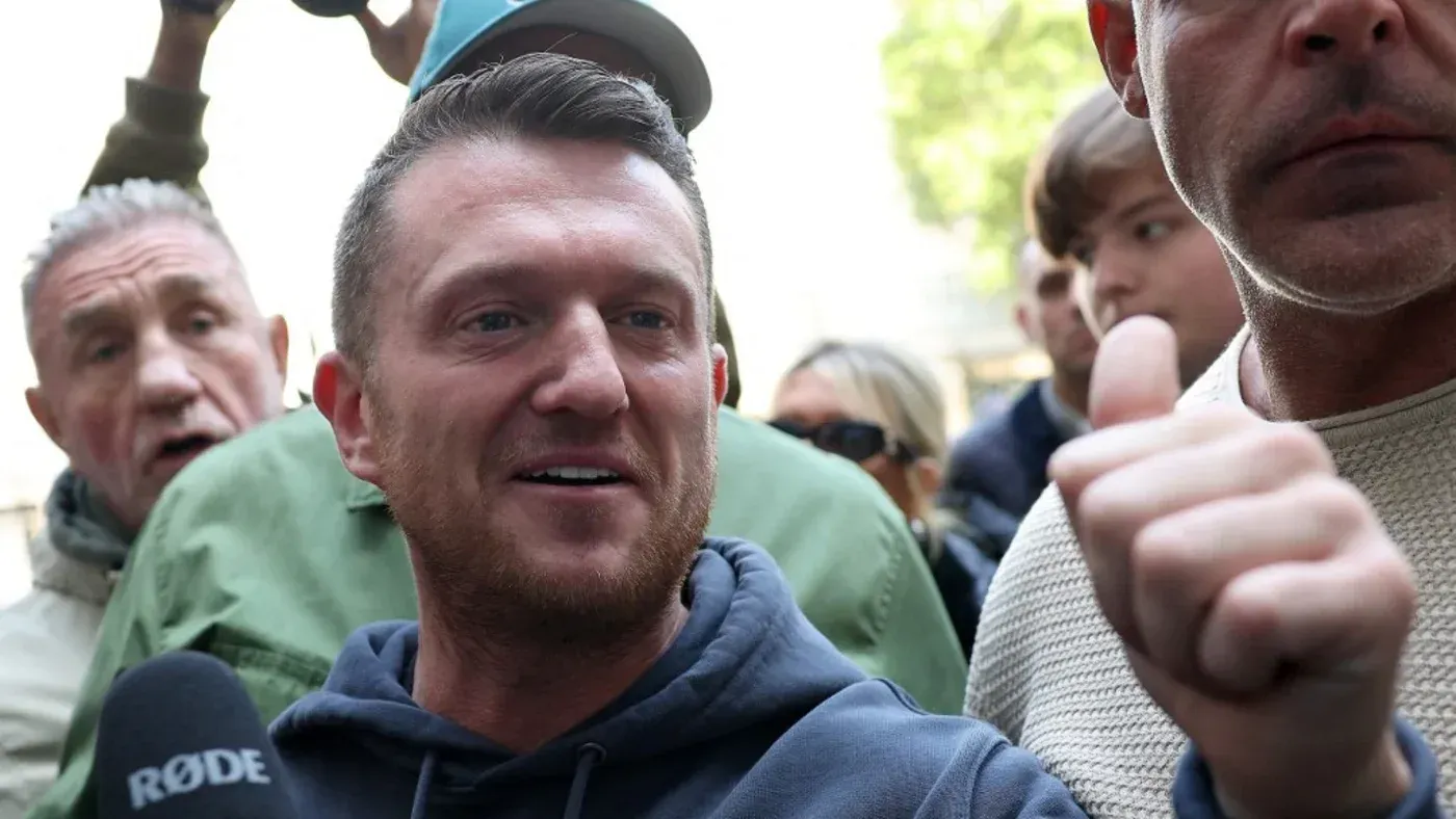 تومي روبنسون، الناشط البريطاني اليميني المتطرف، يتحدث مع مؤيدين في تجمع عام، بينما يواجه انتقادات بسبب مواقفه المثيرة للجدل.