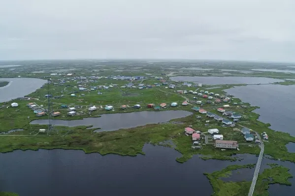 صورة جوية لقرية كيبنوك في ألاسكا، تظهر المنازل المغمورة بالمياه بعد العاصفة، مع مشاهد للفيضانات المحيطة.
