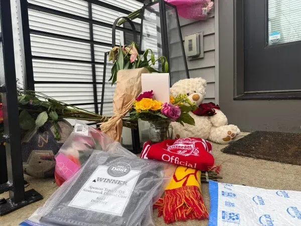 تظهر الصورة زهورًا وألعابًا محشوة وأغراضًا أخرى أمام منزل عائلة تيبي، في إشارة إلى الحزن بعد مقتل الزوجين.