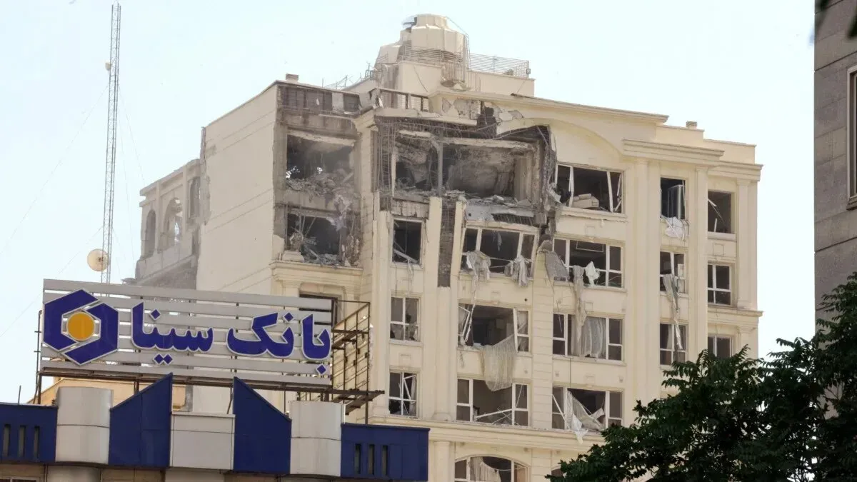 مبنى بنك سيناء في حالة تدمير جزئي بعد الهجوم، مع ظهور نوافذ مكسورة وأضرار واضحة في الهيكل. يتزامن مع تصاعد التوترات في المنطقة.