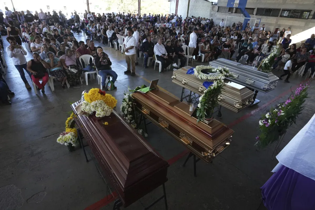 تجمع حشود كبيرة في جنازة جماعية في غواتيمالا، حيث تظهر توابيت مزينة بالزهور وسط أجواء من الحزن بعد حادث مميت.