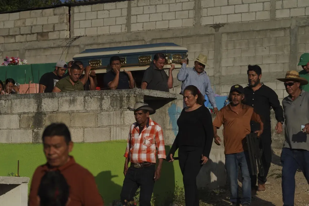 حضور عائلات ضحايا حادث حافلة في سانتو دومينغو لوس أوكوتيس، يتجمعون حول نعش، مع تعبيرات الحزن والأسى.