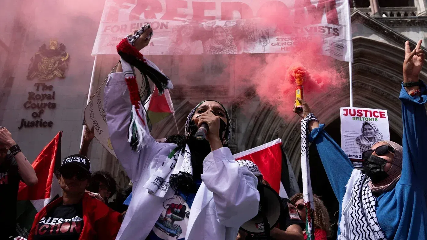 محتجون يحملون أعلام فلسطين ويستخدمون أدوات لإطلاق الدخان الملون أمام المحكمة العليا في لندن، مطالبين بالعدالة للإضراب عن الطعام.