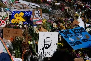 تظهر الصورة نصبًا تذكاريًا لأليكس بريتي، مع لافتات وزهور، تعبيرًا عن الحزن والدعم بعد وفاته المأساوية.