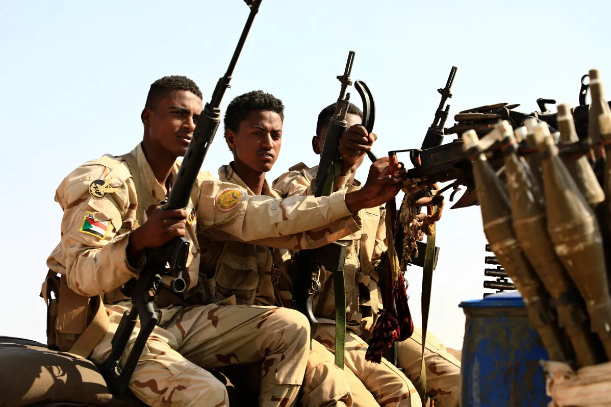 جنود من قوات الدعم السريع يجلسون على مركبة عسكرية، يحملون أسلحة، في سياق تصاعد التوترات حول مدينة الأبيض في السودان.