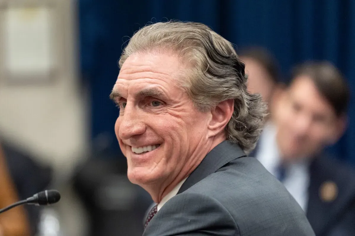 ابتسامة Doug Burgum، وزير الداخلية، خلال جلسة استماع، تعكس التوترات حول سياسات الطاقة المتجددة في الولايات المتحدة وتأثيرها على مشاريع الطاقة النظيفة.