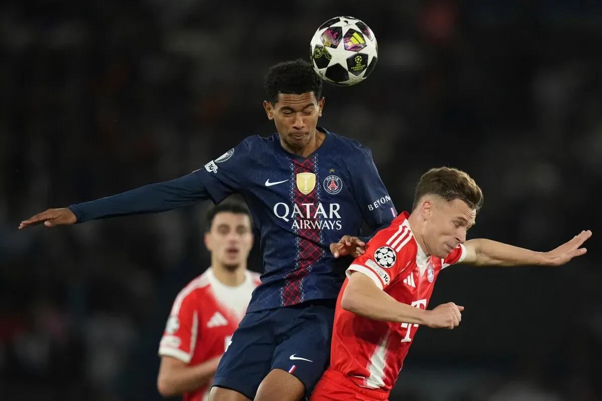 لاعب من فريق باريس سان جيرمان يتنافس مع لاعب من بايرن ميونيخ خلال مباراة دوري أبطال أوروبا، مع التركيز على التحديات البدنية بين اللاعبين.