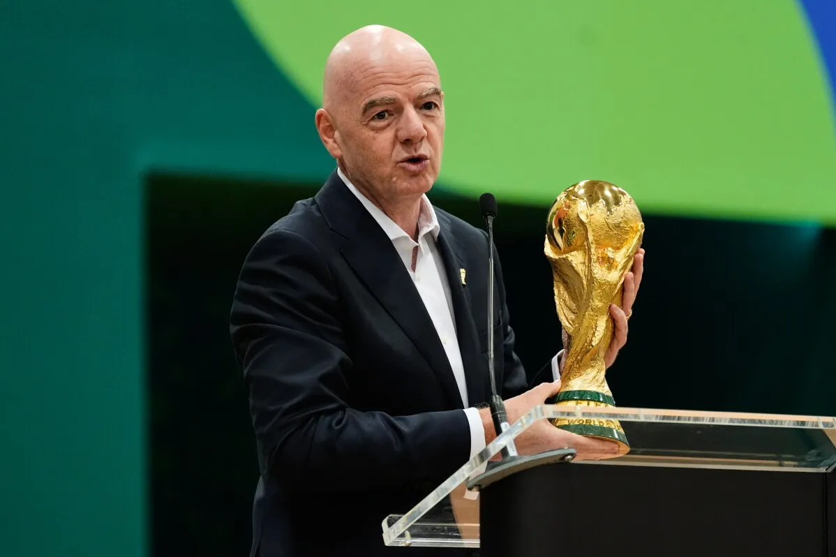 Gianni Infantino يتحدث أمام الجمهور حاملاً كأس العالم، في حدث يسلط الضوء على الأضواء السياسية المرتبطة بكأس العالم 2026.