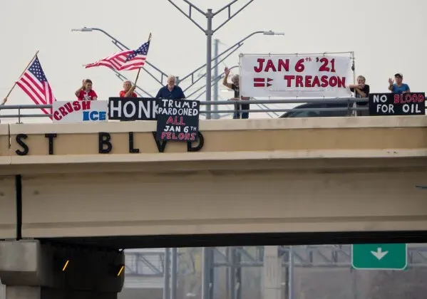 محتجون يحملون لافتات في ذكرى أحداث 6 يناير 2021، تعبيرًا عن آراء متباينة حول الهجوم على الكابيتول.
