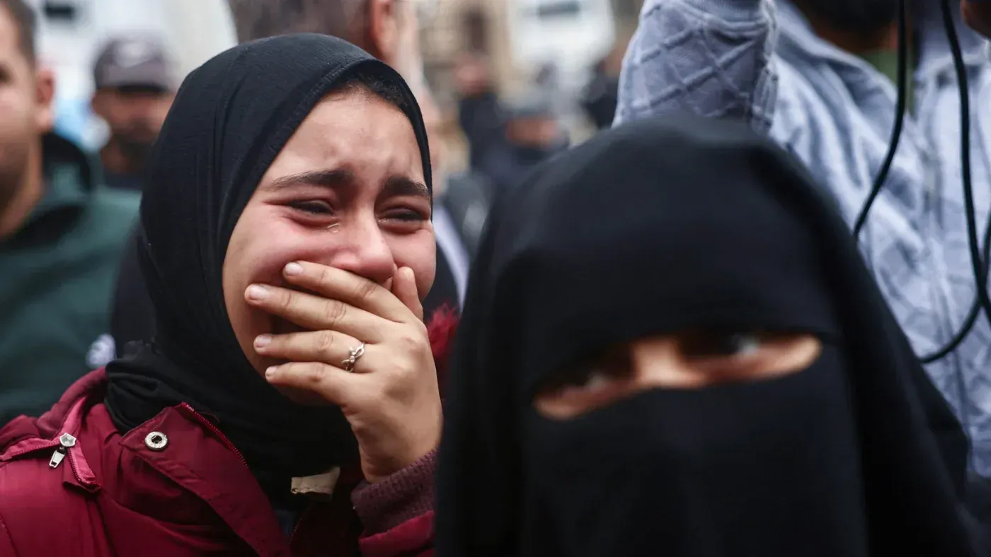 امرأة تبكي بحرقة في تجمع شعبي، تعبيرًا عن الحزن بعد الغارات الإسرائيلية على غزة، حيث قُتل العديد من الفلسطينيين، بينهم أطفال.