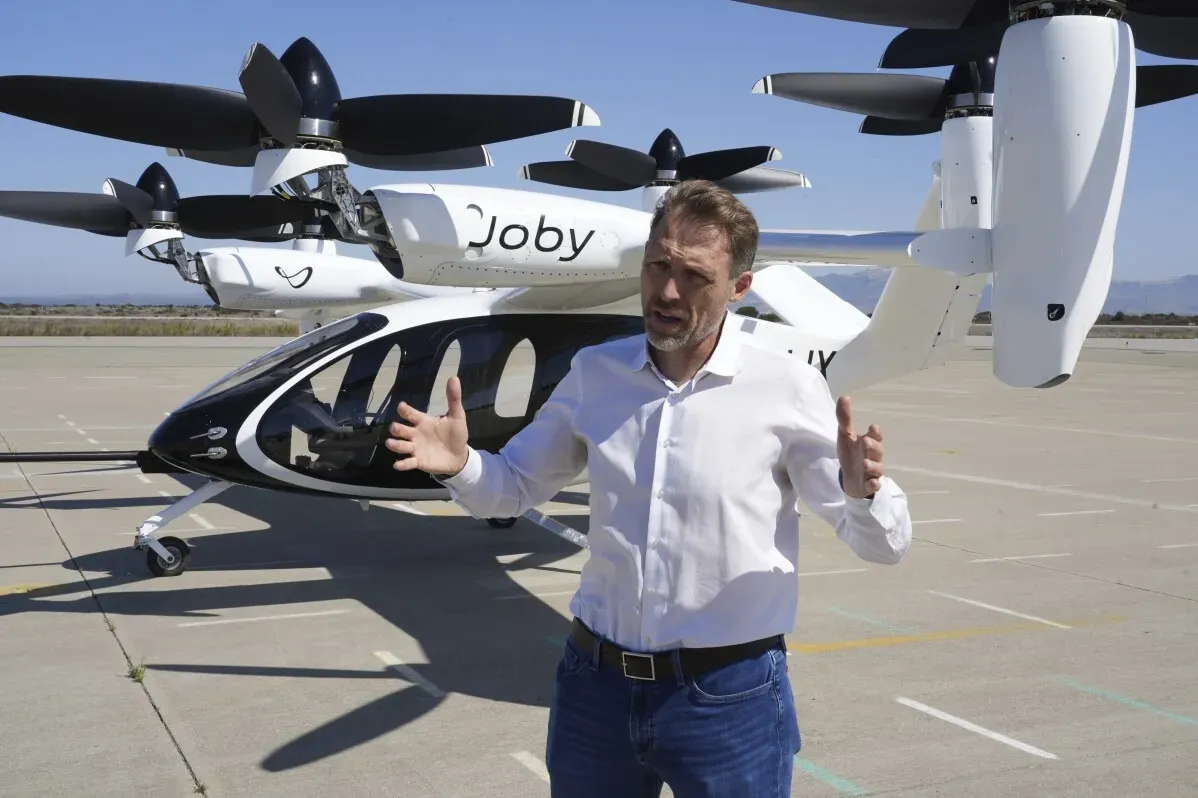 رجل يتحدث أمام طائرة eVTOL من شركة جوبي، التي تهدف إلى تحويل التنقل الجوي باستخدام التكنولوجيا الكهربائية.
