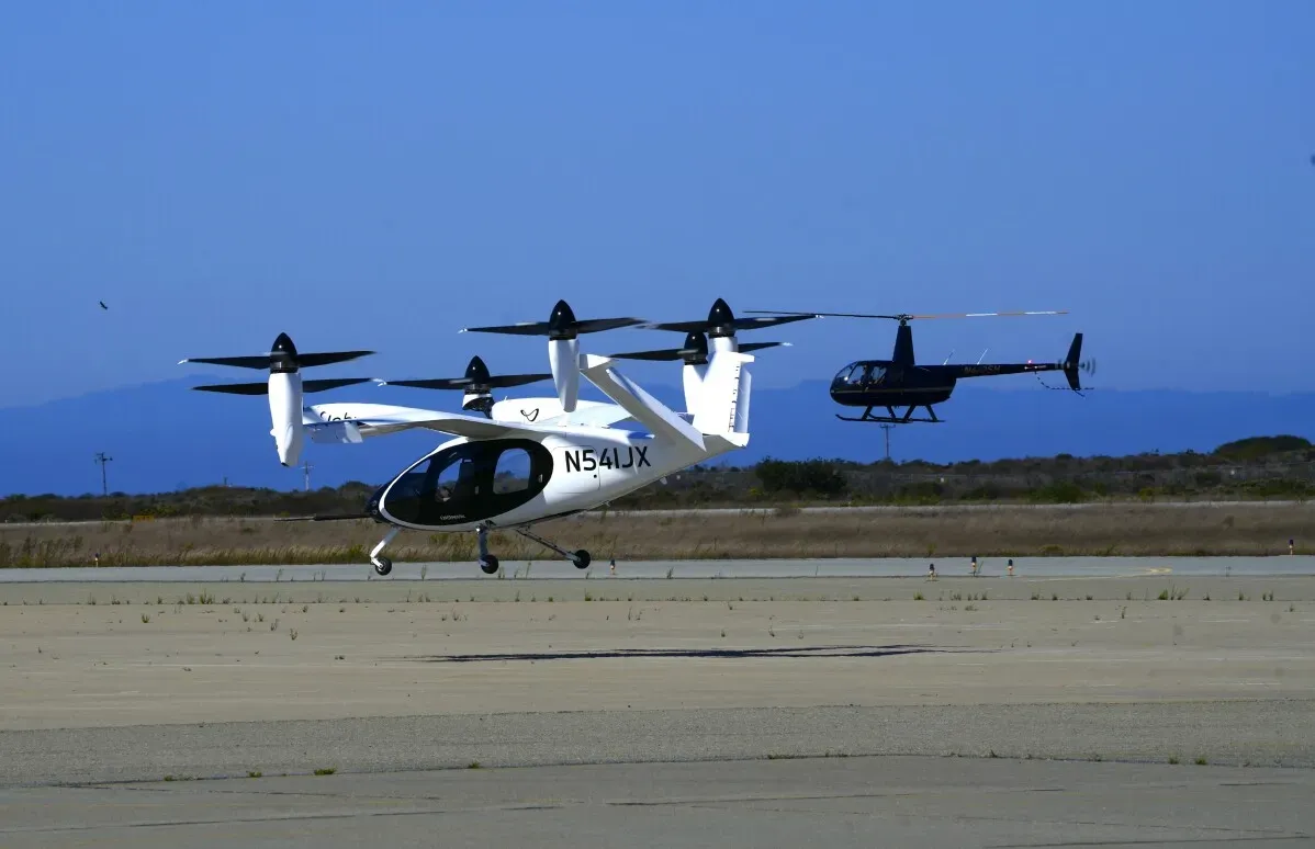 مركبة eVTOL الكهربائية تقلع على مدرج، بجوار طائرة هليكوبتر، تمثل خطوة نحو تحويل الرحلات الجوية إلى سيارات أجرة في السماء.