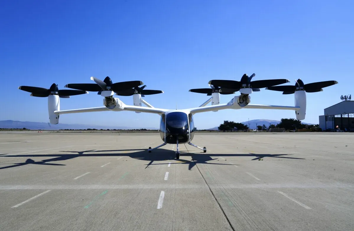 طائرة كهربائية عمودية eVTOL تتواجد على مدرج، تتميز بتصميمها العصري وأربعة مراوح، تمثل مستقبل النقل الجوي.