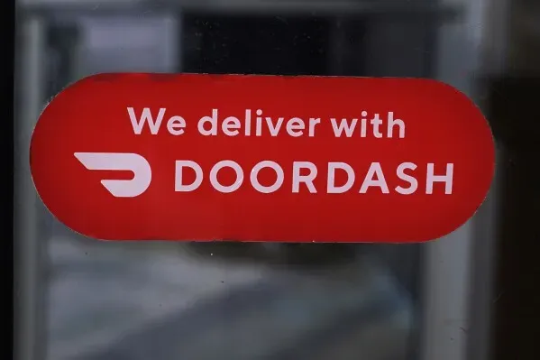 شعار "نحن نوصل مع DoorDash" على خلفية حمراء، يشير إلى شراكة Deliveroo مع DoorDash في توصيل الطعام.