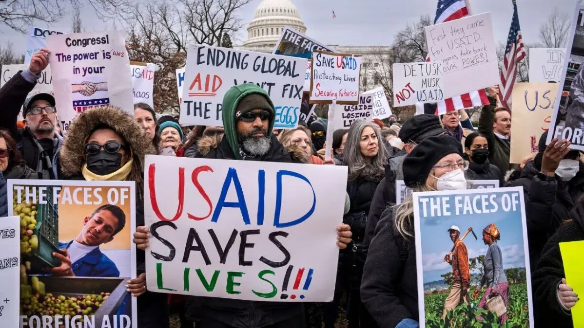 محتجون يحملون لافتات تدعو للحفاظ على وكالة المساعدات الأمريكية (USAID) وسط أجواء من التوتر في واشنطن.