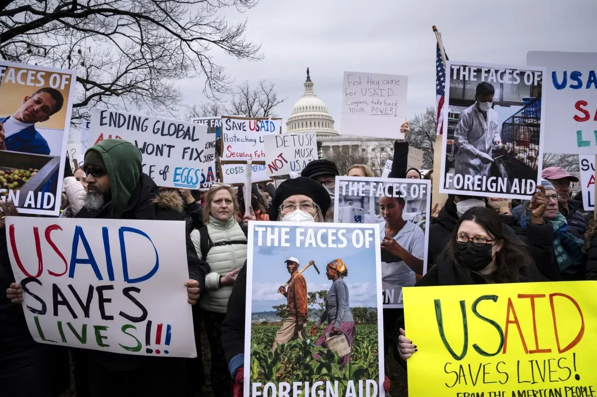محتجون يحملون لافتات تدعم الوكالة الأمريكية للتنمية الدولية (USAID) أمام مبنى الكابيتول، مع التركيز على أهمية المساعدات الخارجية.