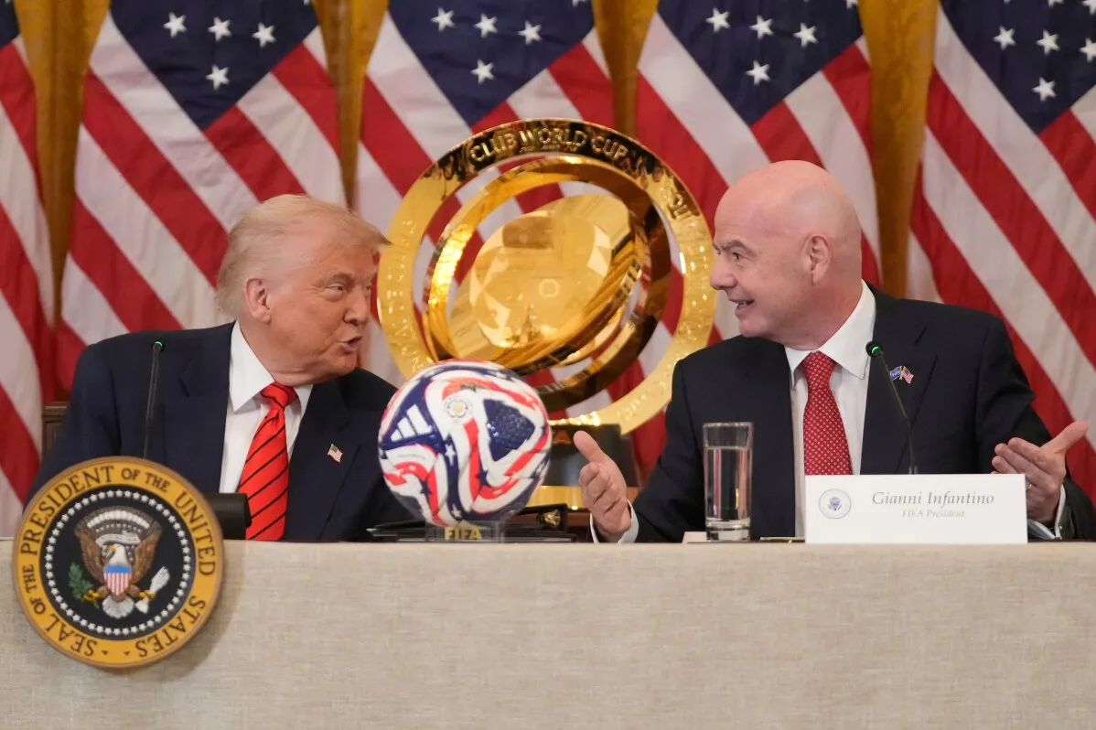 ترامب وجيانني إنفانتينو يتحدثان خلال مؤتمر صحفي حول كأس العالم، مع وجود كأس البطولة وكرة قدم ملونة على الطاولة.