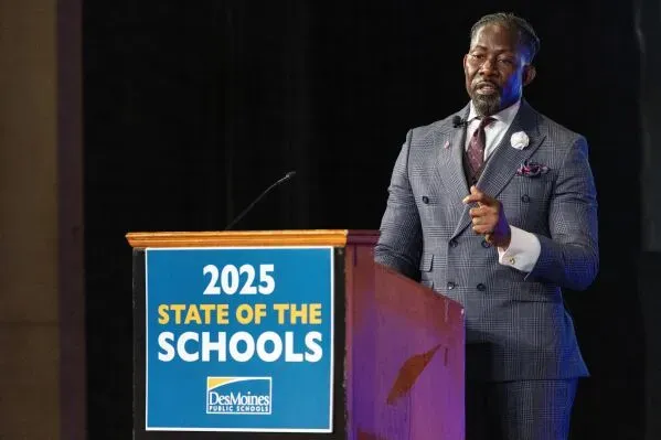 إيان روبرتس، المدير السابق لمدارس دي موين، يتحدث في حدث "حالة المدارس 2025"، وسط أجواء رسمية.