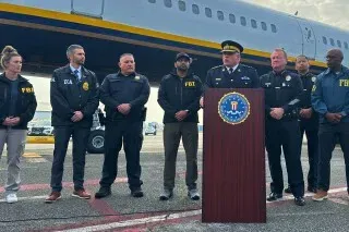 اعتقال ريان ويدينج، المتزلج الأولمبي السابق، في المكسيك، حيث يتحدث مسؤولون من مكتب التحقيقات الفيدرالي عن العملية أمام طائرة.