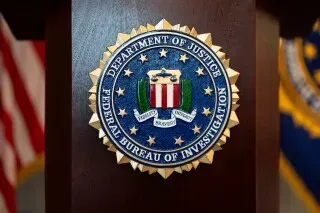 شعار مكتب التحقيقات الفيدرالي (FBI) مع خلفية رمادية، يمثل جهود السلطات في مكافحة تهريب المخدرات والجرائم المنظمة.
