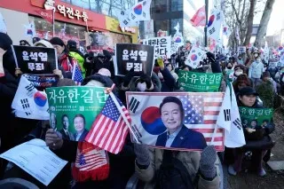 محتجون يحملون لافتات وصورًا للرئيس الكوري الجنوبي السابق يون سوك يول، مع أعلام كورية وأمريكية، خلال تجمع أمام المحكمة.