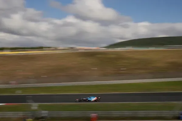 سيارة سباق فورمولا 1 تسير بسرعة على حلبة إسطنبول بارك، مع خلفية تتضمن سماء زرقاء وغيوم، تعكس عودة السباق إلى تركيا.