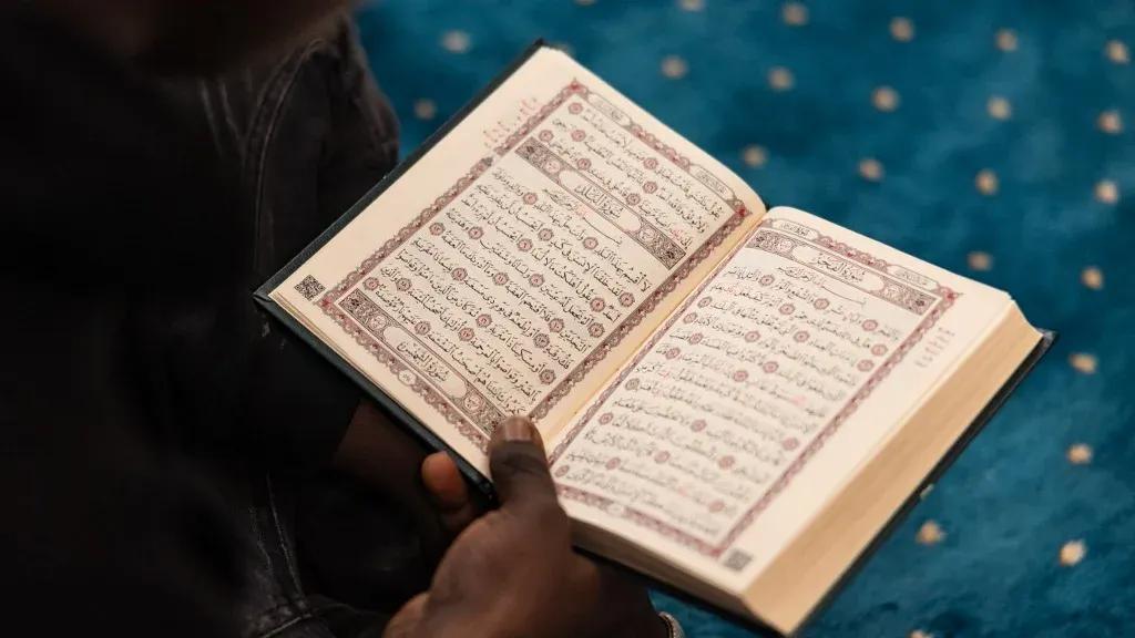 شخص يمسك بمصحف مفتوح داخل مسجد، يعكس الجدل حول إغلاق مسجد Attaqwa في ضاحية أولناي-سو-بوا شمال باريس بسبب اتهامات بالتحريض على العنف والإرهاب.