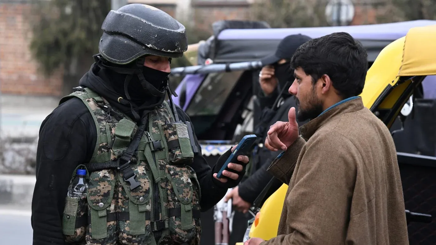 جندي هندي يرتدي زيًا عسكريًا ويتحقق من هوية شاب في كشمير في ظل إجراءات أمنية مشددة بعد إلغاء الوضع الدستوري الخاص بالمنطقة.