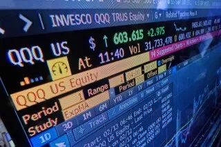 شاشة عرض تعرض بيانات سوق الأسهم لصندوق QQQ، مع أسعار الأسهم وحجم التداول، تعكس نشاط المستثمرين الأفراد في السوق.