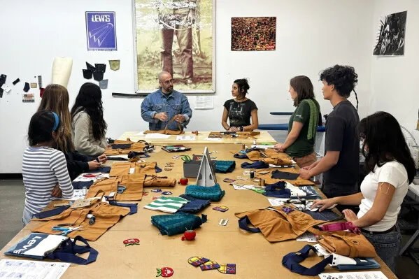 طلاب يتعلمون مهارات الخياطة اليدوية في ورشة تعليمية ضمن برنامج Levi's لتعزيز الاستدامة وترميم الملابس لجيل Z.