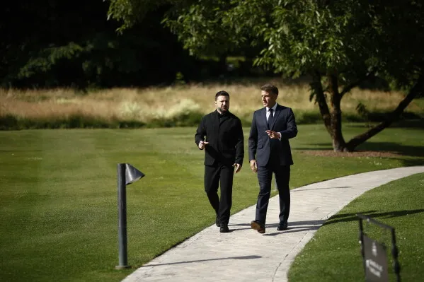 الرئيس الأوكراني زيلينسكي يتحدث مع مسؤول فرنسي في منتجع إيفيان-ليه-بان خلال قمّة مجموعة السبع، وسط أجواء مناقشات حول الحرب في أوكرانيا.