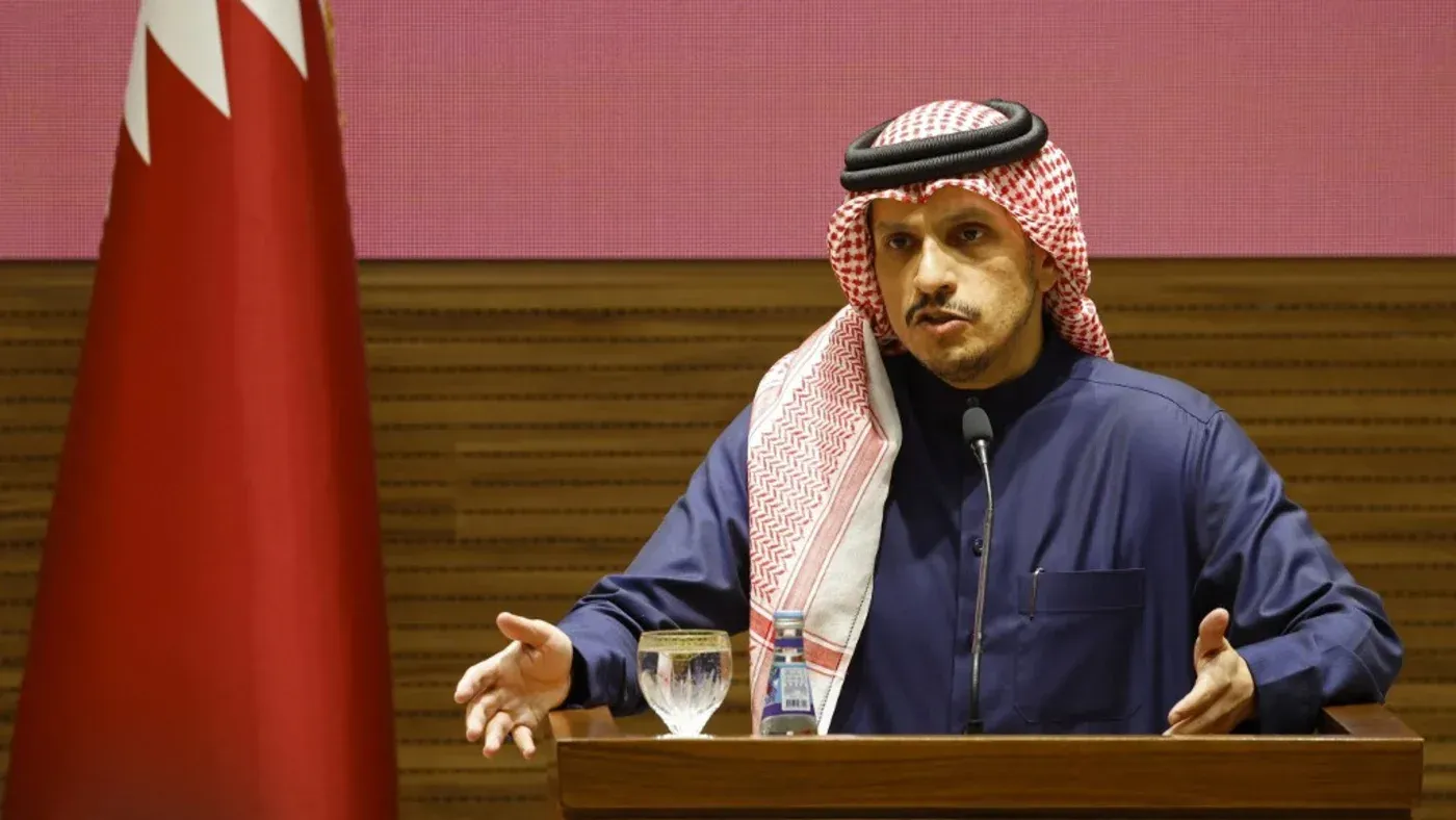 وزير قطري يتحدث خلال مؤتمر صحفي، مع العلم القطري خلفه، متناولًا جهود الوساطة في النزاع الإسرائيلي الفلسطيني.