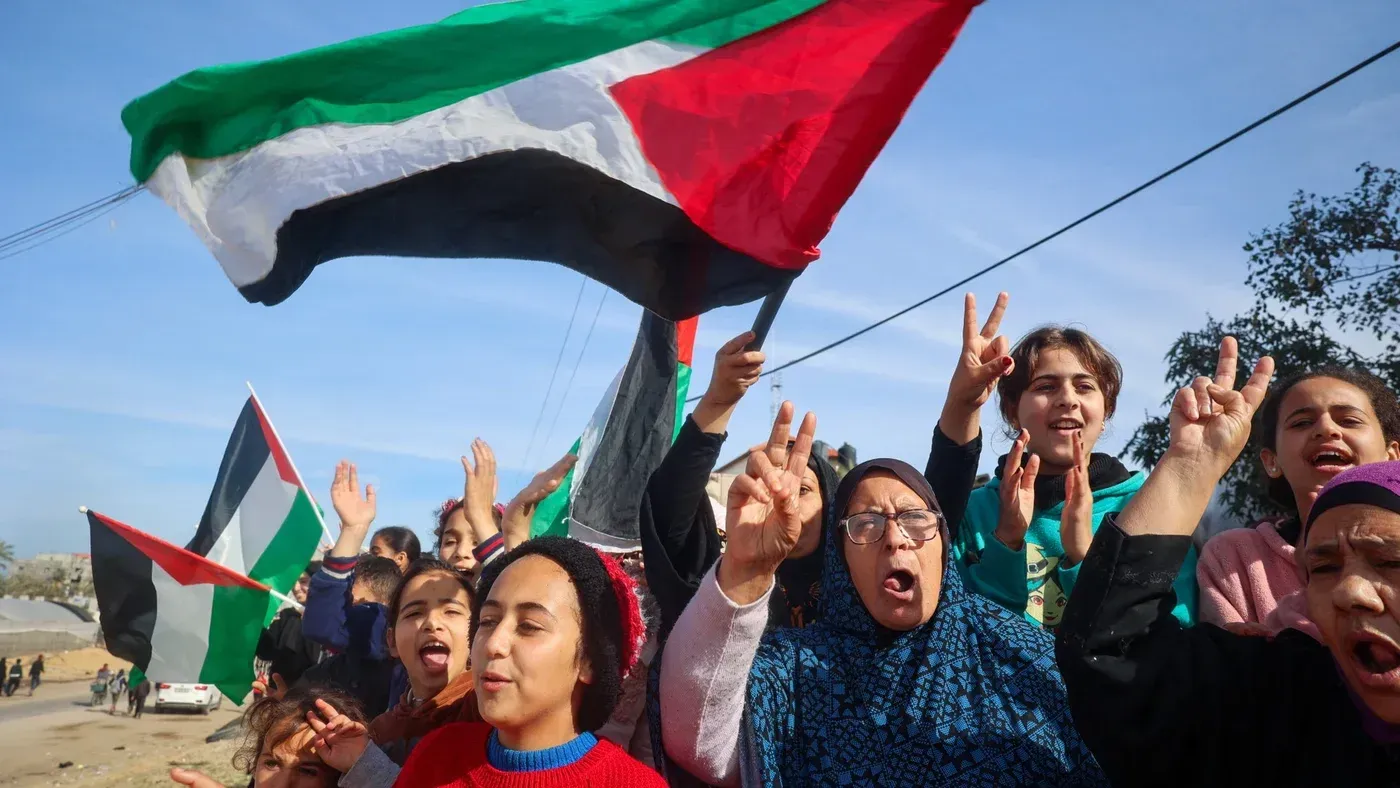 نساء وأطفال فلسطينيون يحملون الأعلام الوطنية ويحتفلون بصفقة تبادل الأسرى، ويرددون شعارات تحمل رسائل التضامن.