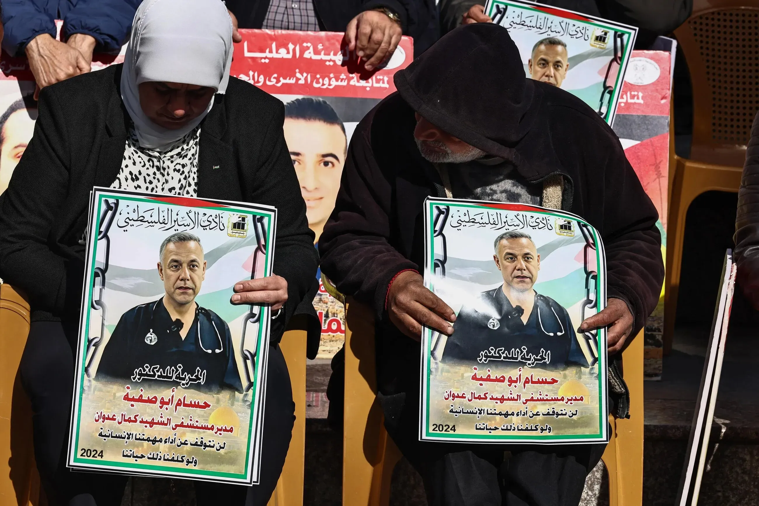 محتجون يحملون لافتات تحمل صورة الدكتور حسام أبو صفية، مدير مستشفى كمال عدوان، في فعالية تضامنية تسلط الضوء على معاناته في السجون الإسرائيلية.