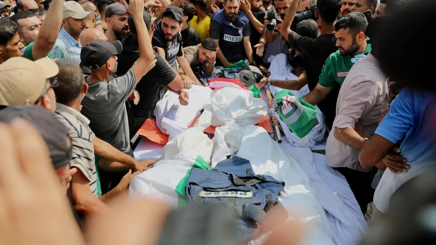 تشييع جثامين ستة صحفيين فلسطينيين في غزة، حيث يتجمع الصحفيون والمشاركون حول الأعلام والستر المكتوب عليها "صحافة".