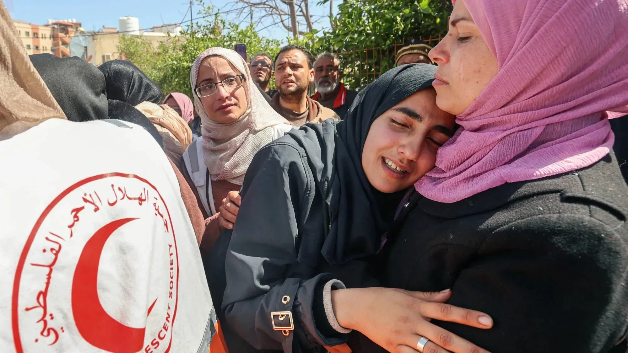نساء فلسطينيات يعبرن عن حزنهن خلال مراسم تأبين مسعفين من جمعية الهلال الأحمر الفلسطيني الذين قُتلوا في رفح.