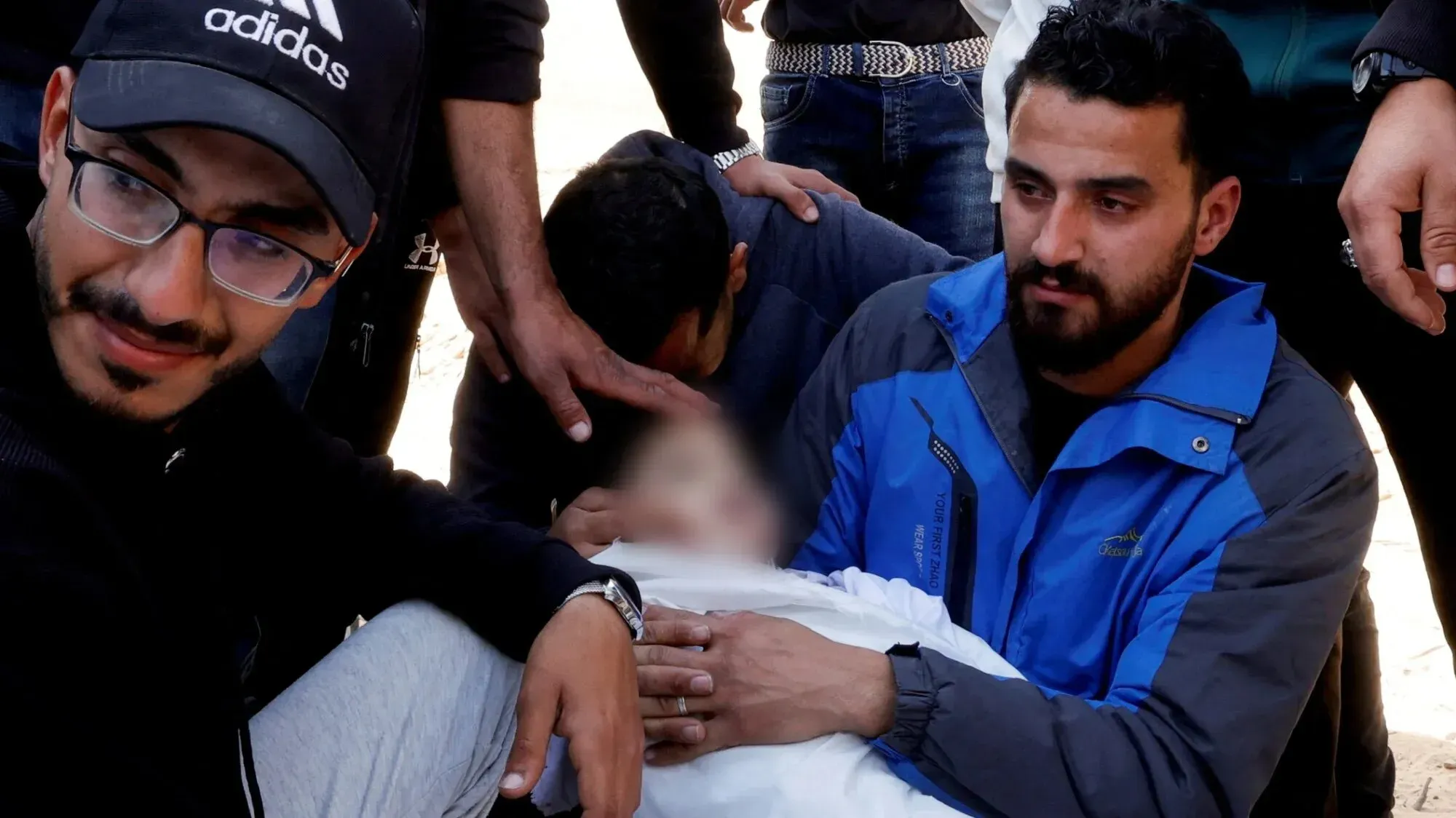 مواطنون فلسطينيون في حالة حزن شديد بعد فقدان طفل في قصف إسرائيلي، يظهرون مشاعر الألم والفقد خلال عيد الأضحى.